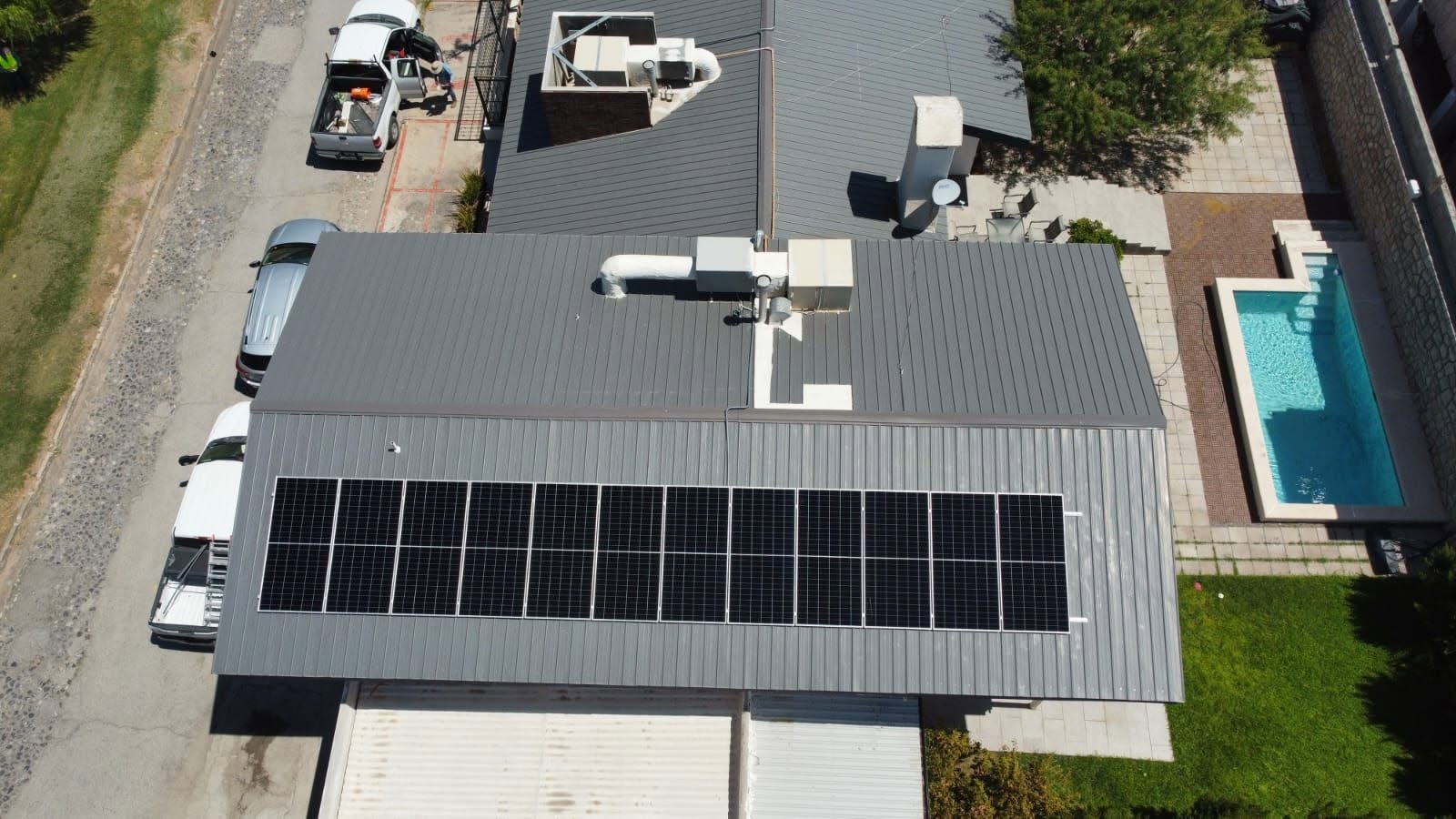 Vista aérea de 12 paneles solares instalados sobre el techo de lámina de una casa en Ciudad Juárez
