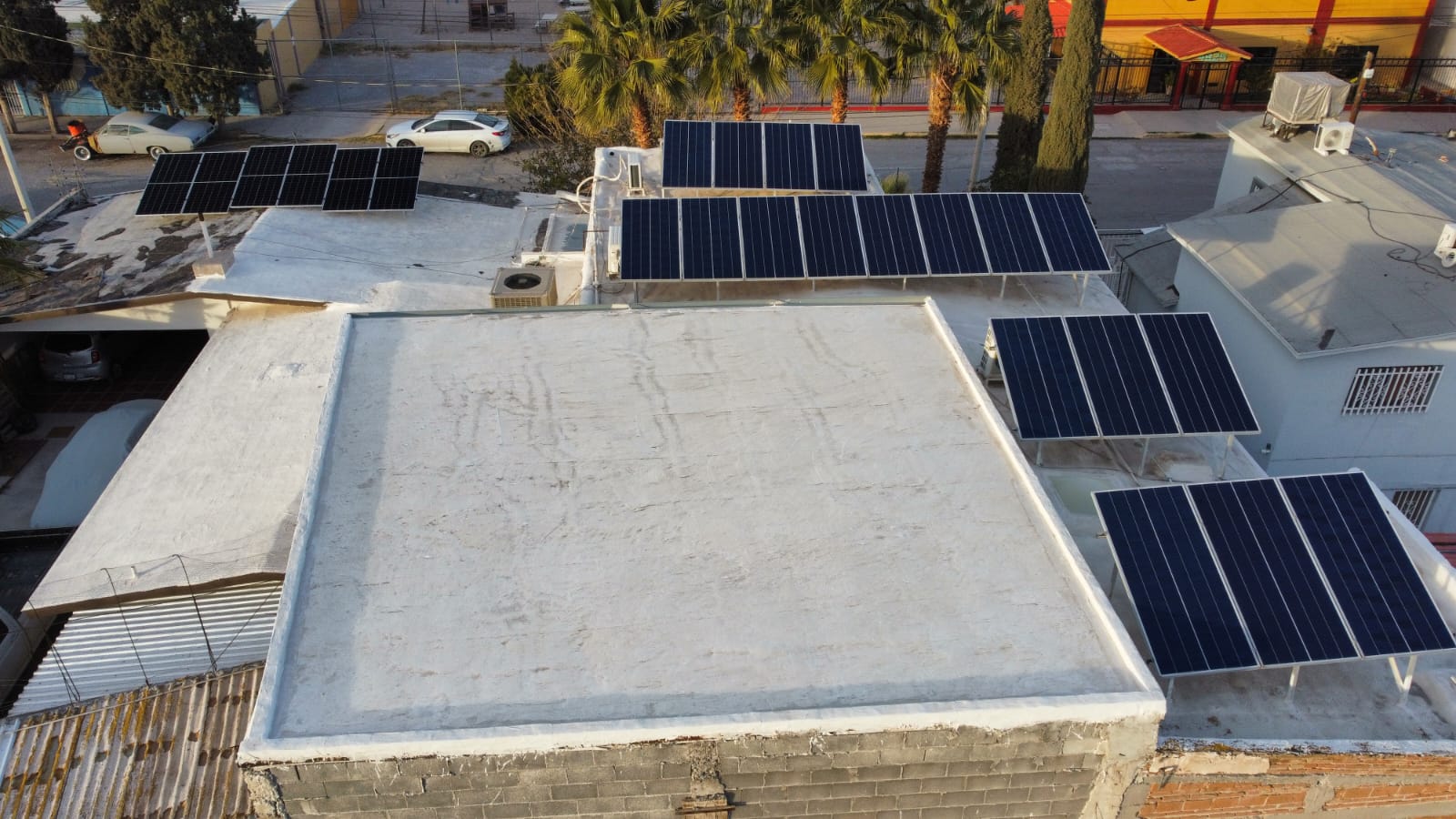 Vista aérea de varios arreglos de paneles solares instalados sobre la azotea blanca de un local comercial en Ciudad Juárez
